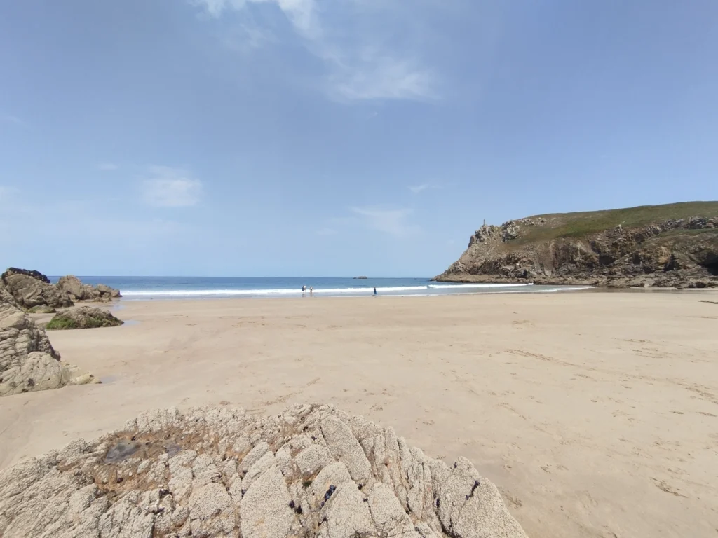 photo de la plage de theolens à marée basse, entourée de falaises.
