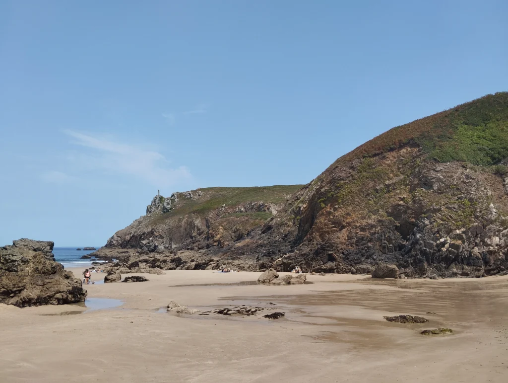 photo de la plage de theolens à marée basse, entourée de falaises.
